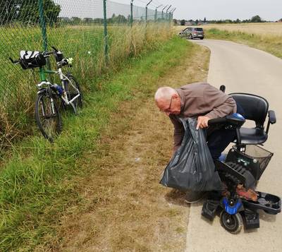 En fauteuil roulant, ce vieil homme ramasse les déchets le long de la route