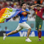 un supporteur fait irruption sur la pelouse pour brandir le drapeau LGBT lors du match Portugal-Uruguay